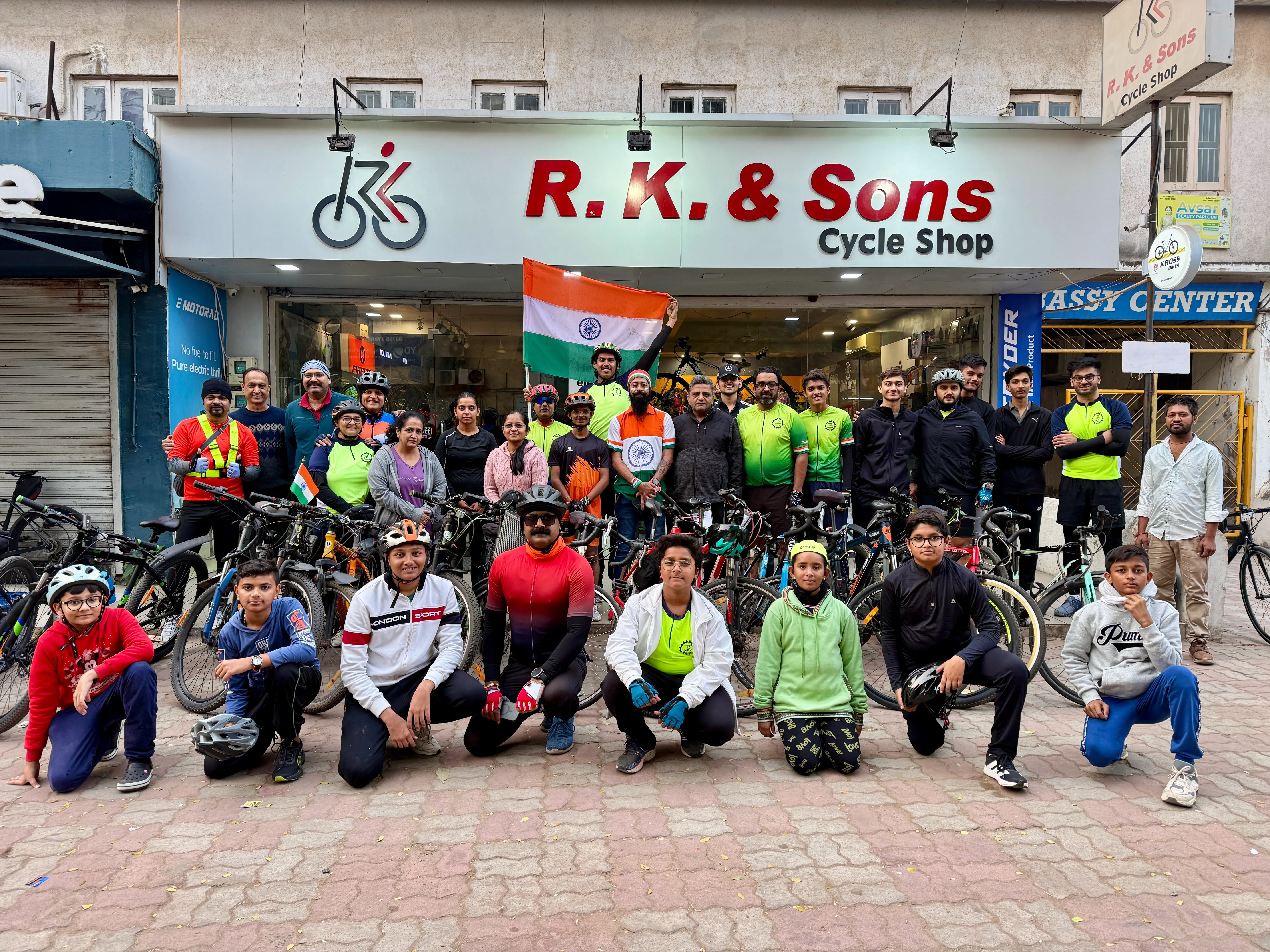 Club riders with national flag and cycles outside R. K. & Sons